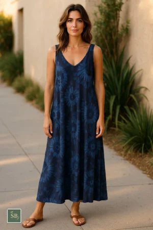 Woman wearing a sleeveless navy blue floral tie-dye summer dress outdoors