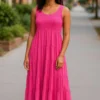 Woman wearing a sleeveless hot pink tiered summer dress on a city street