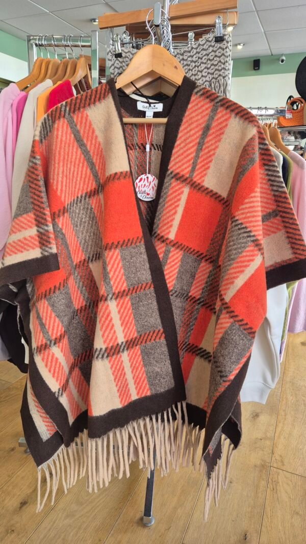 2026/09/JPEG_20260925_115136_8961473610849175778-scaled.jpg Orange/Chocolate Patterned Fringed Poncho